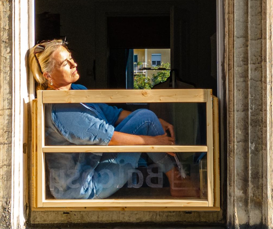 Frau sitzt am Balcosy in der Sonne